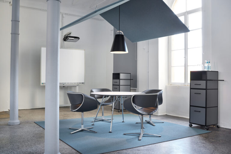 Besprechungstisch mit vier designorientierten Besprechungstuehlen in blauem Leder und verchromtem Stuhlgestell